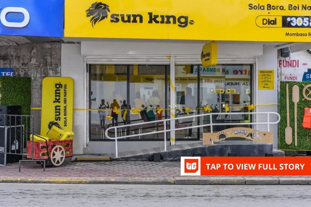 Un ingénieur de Sun King installe des panneaux solaires sur un toit de maison