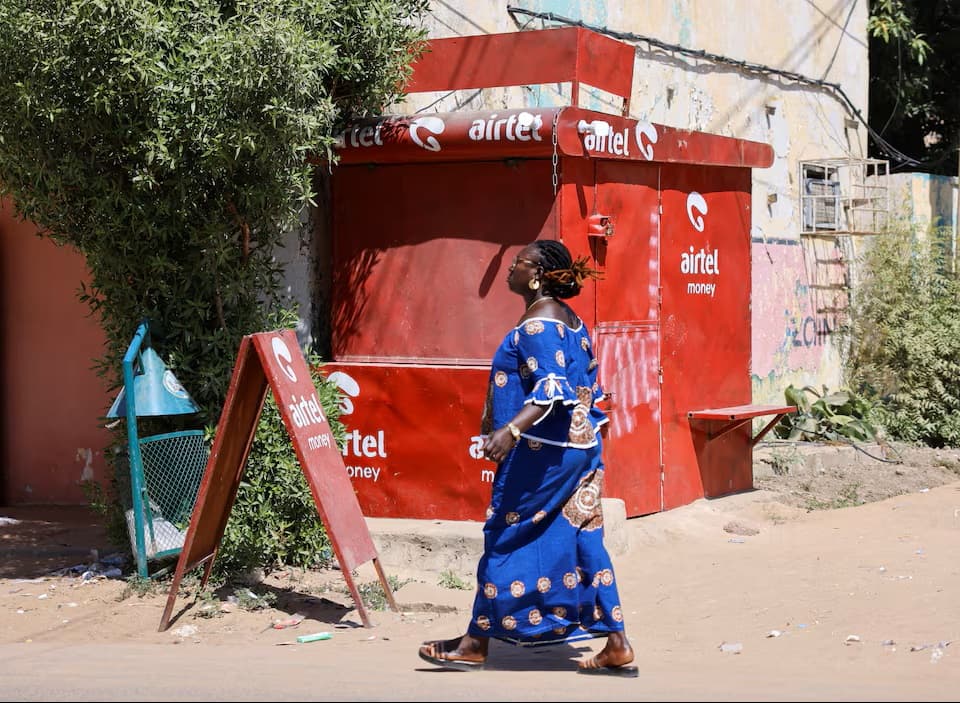 Une femme tchadienne passe devant un kiosque d'Airtel Africa, fournisseur de services de télécommunications et de mobile money, dans la capitale N'Djamena, au Tchad, le 15 novembre 2025