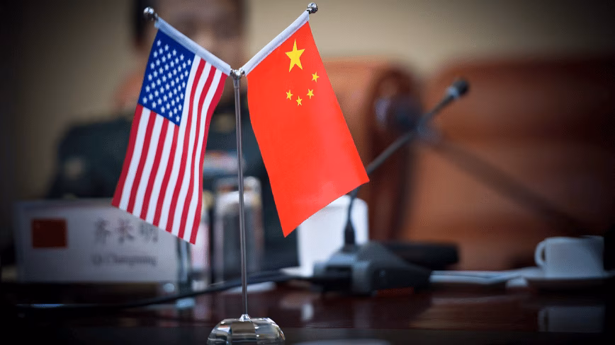 Drapeaux des États-Unis et de la Chine sur une table lors d'une réunion bilatérale à Pékin.